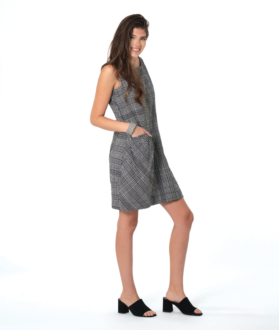 model in a black, white and grey plaid sleeveless shift dress with a squared collar