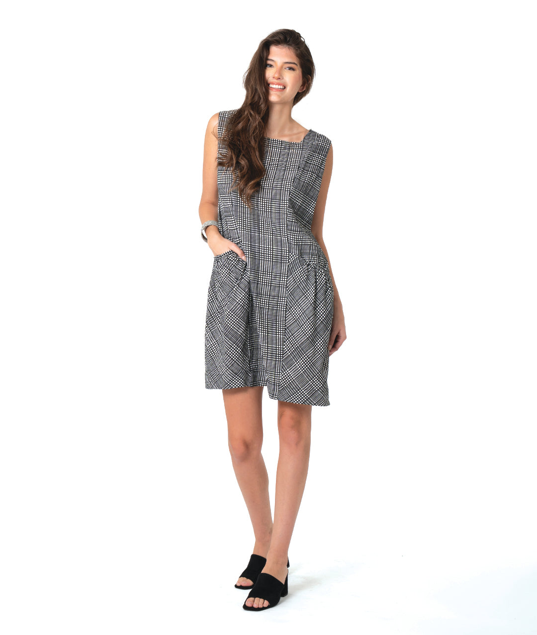 model in a black, white and grey plaid sleeveless shift dress with a squared collar