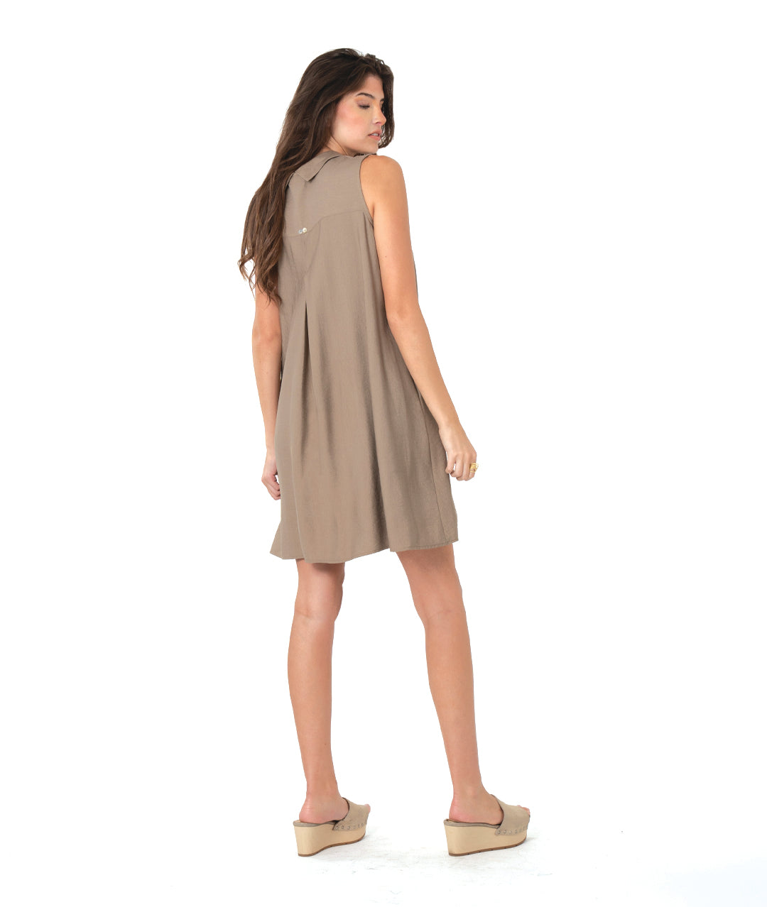 Woman wearing a taupe brown sleeveless shirt dress on a white background