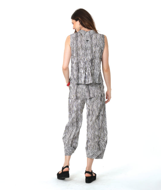 model in a wide leg black and white striped pant with a tapered ankle, worn with a matching sleeveless button down blouse