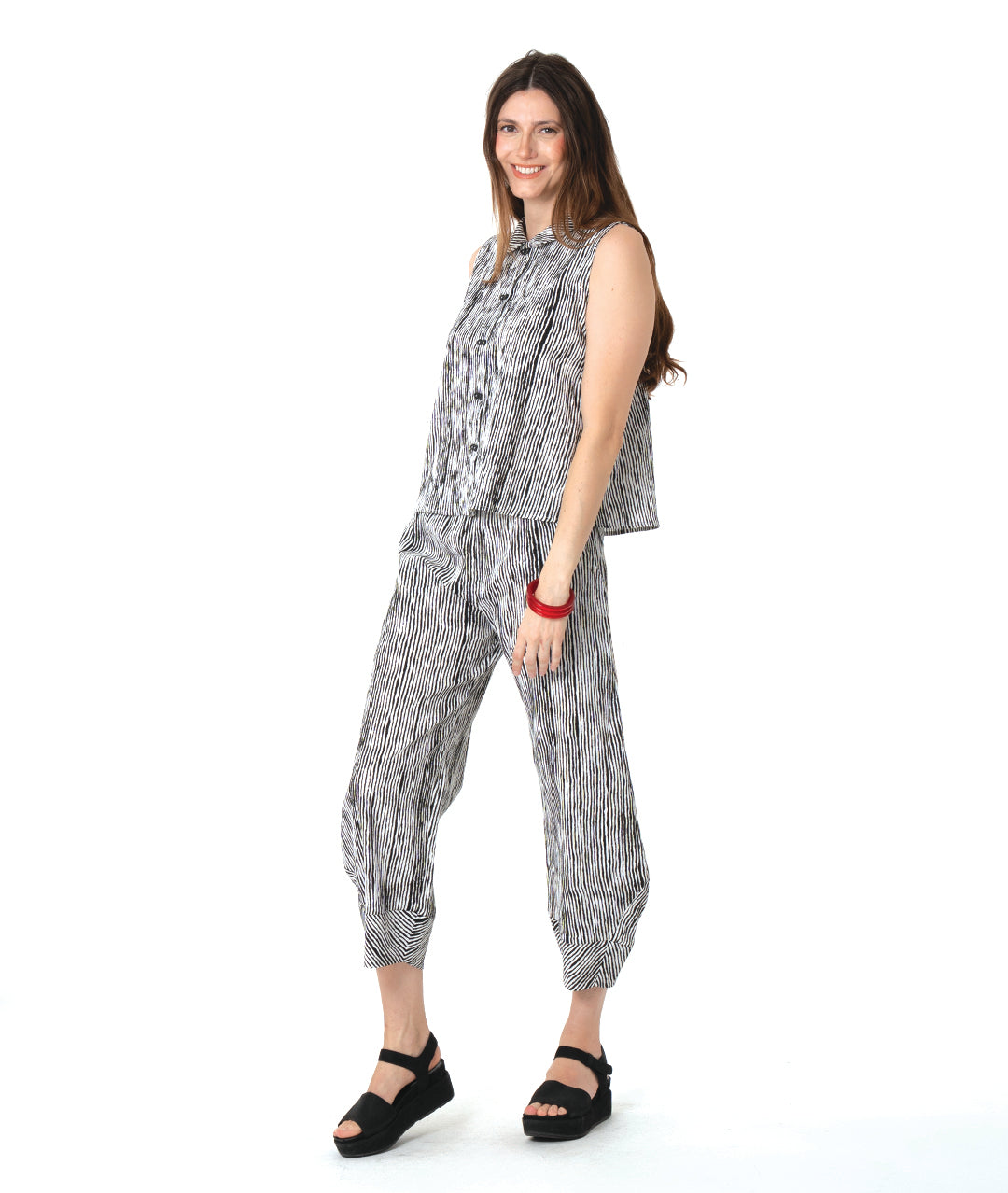 model in a wide leg black and white striped pant with a tapered ankle, worn with a matching sleeveless button down blouse