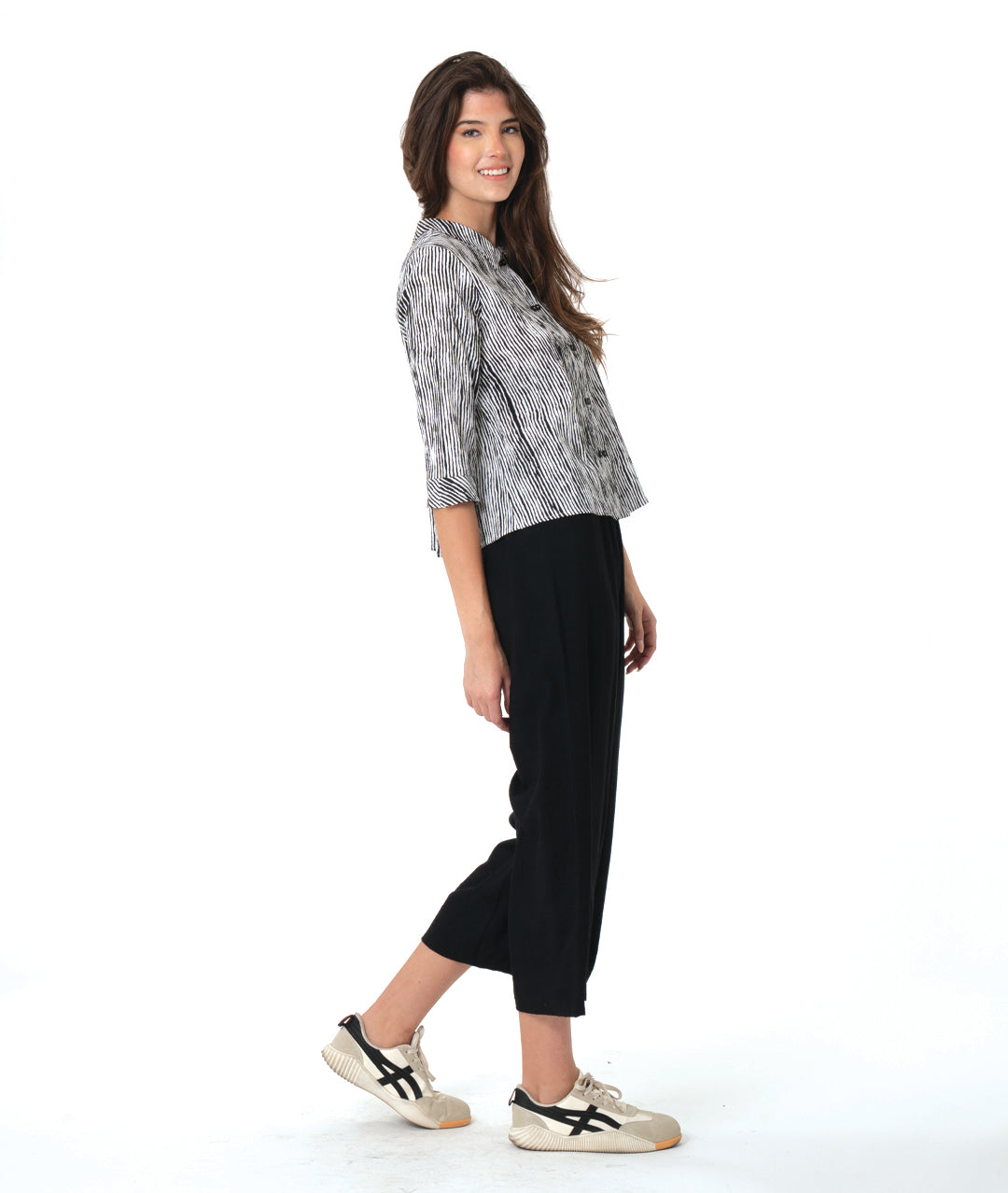 model in a wide leg black pant with a split at the ankle front, worn with a black and white striped blouse with 3/4 sleeves and a twin button detail