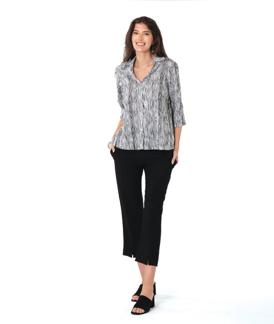 model in a slim black pant with a black and white striped 3/4 pullover 