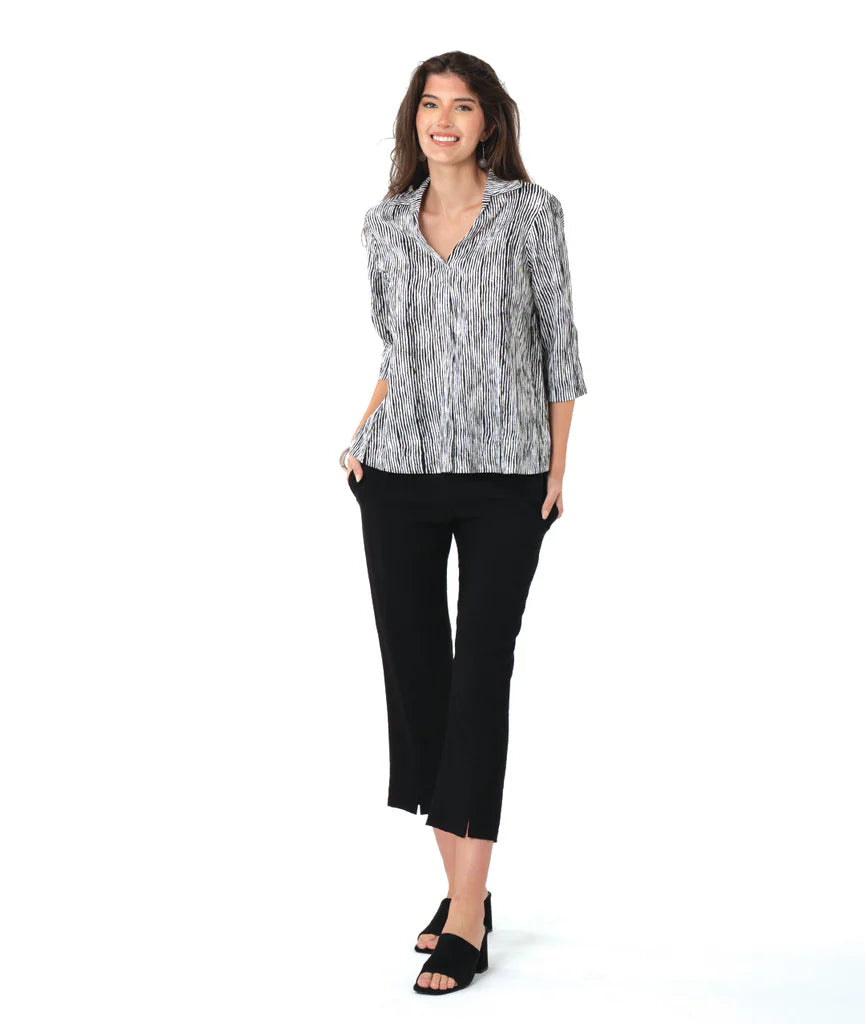 Woman wearing a striped black and white top and black pants on a white background