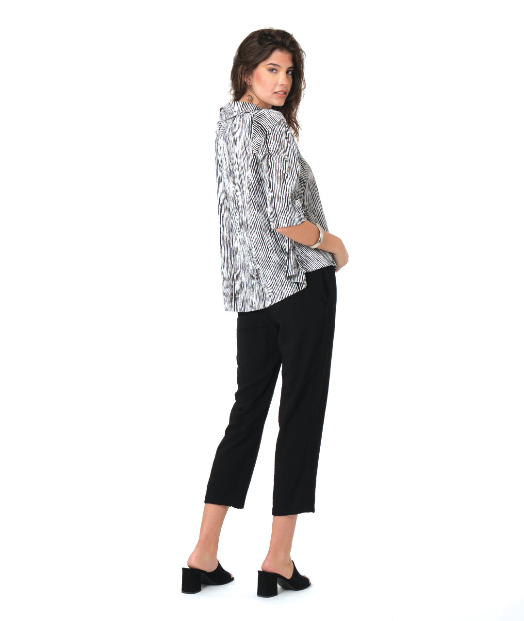 model in a slim black pant with a black and white striped 3/4 pullover 