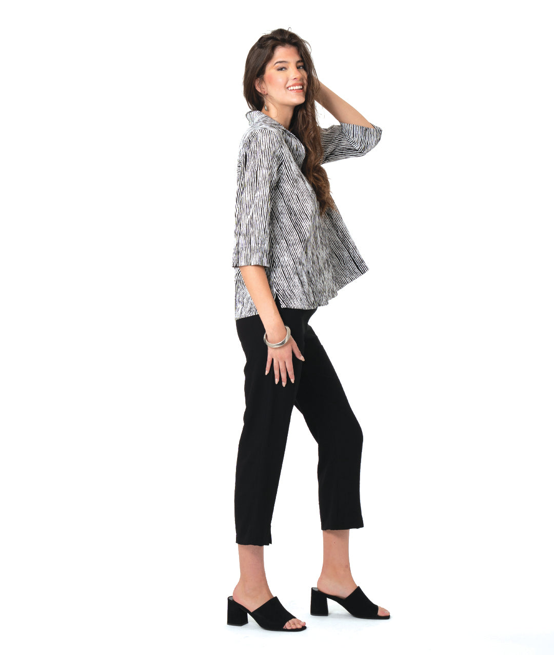 model in a slim black pant with a black and white striped 3/4 pullover 