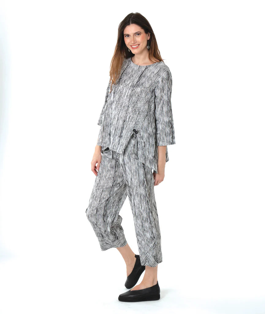 Woman wearing a black and white patterned top and pants on a white background