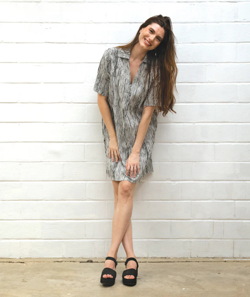Woman wearing a striped black and white dress on a white background