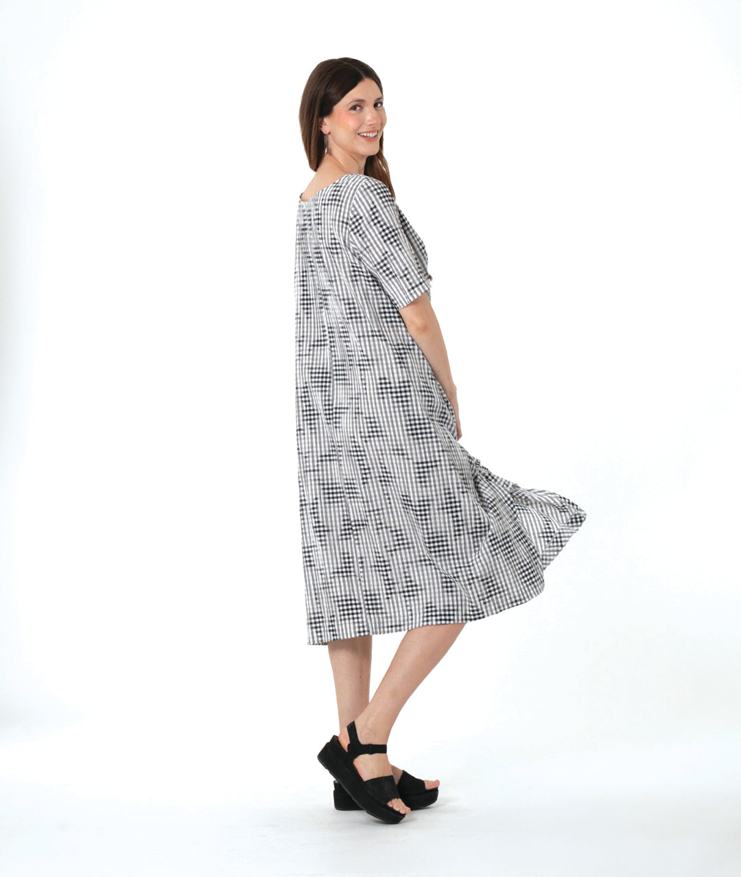 model in a grey plaid dress with asymmetrical tucks and panels