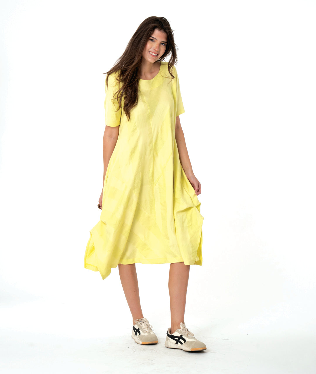 Woman wearing a bright yellow dress on a white background