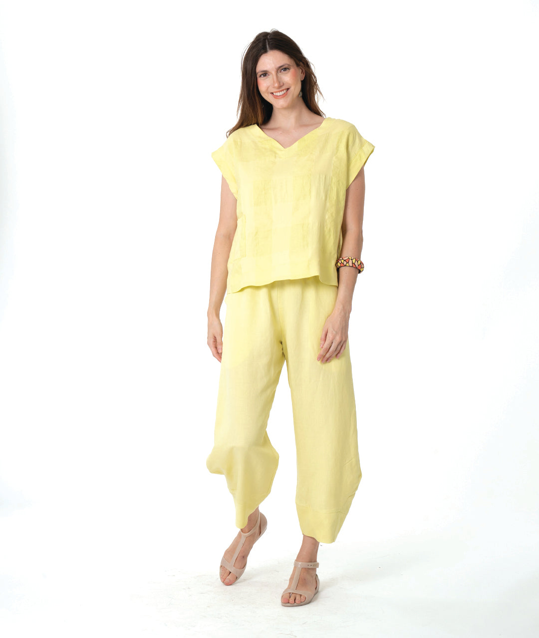 model in a boxy yellow pullover top with a matching barrel leg pant