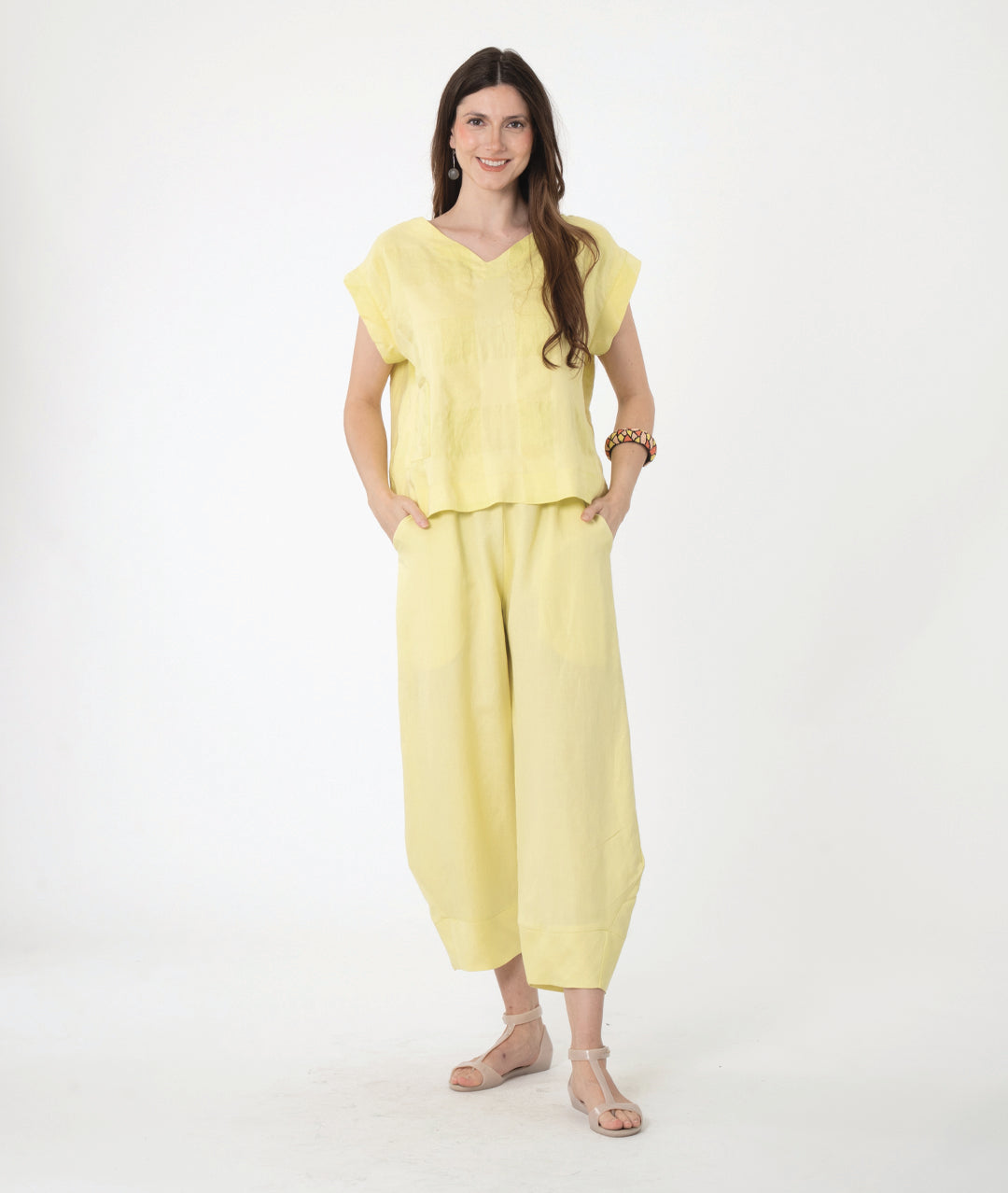 model in a boxy yellow pullover top with a matching barrel leg pant