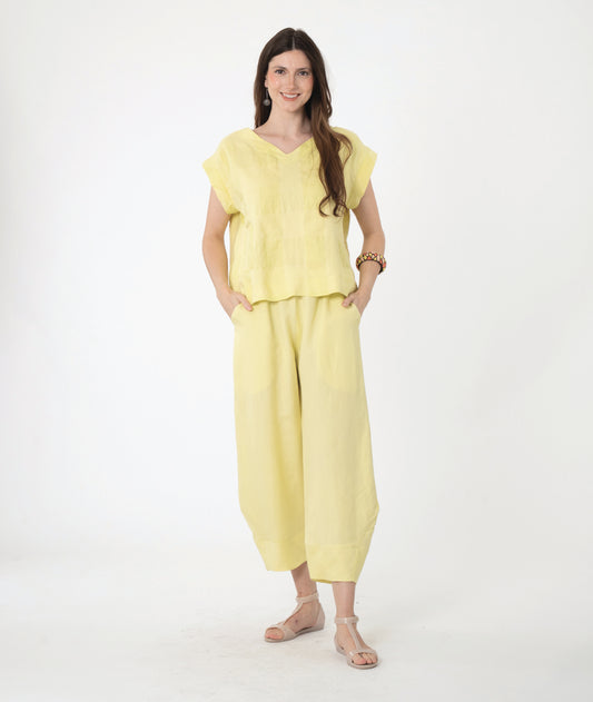 model in a boxy yellow pullover top with a matching barrel leg pant