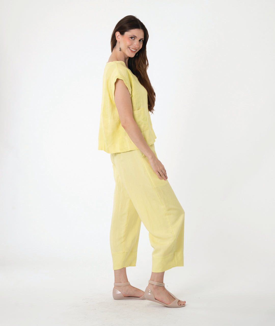 model in a boxy yellow pullover top with a matching barrel leg pant