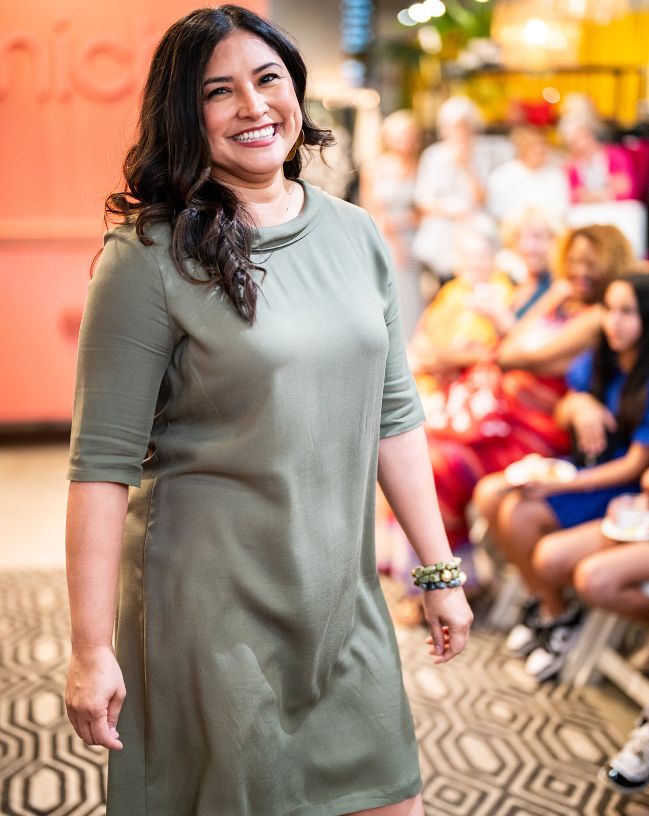 model wearing knee length olive green dress  with elbow length sleeves 