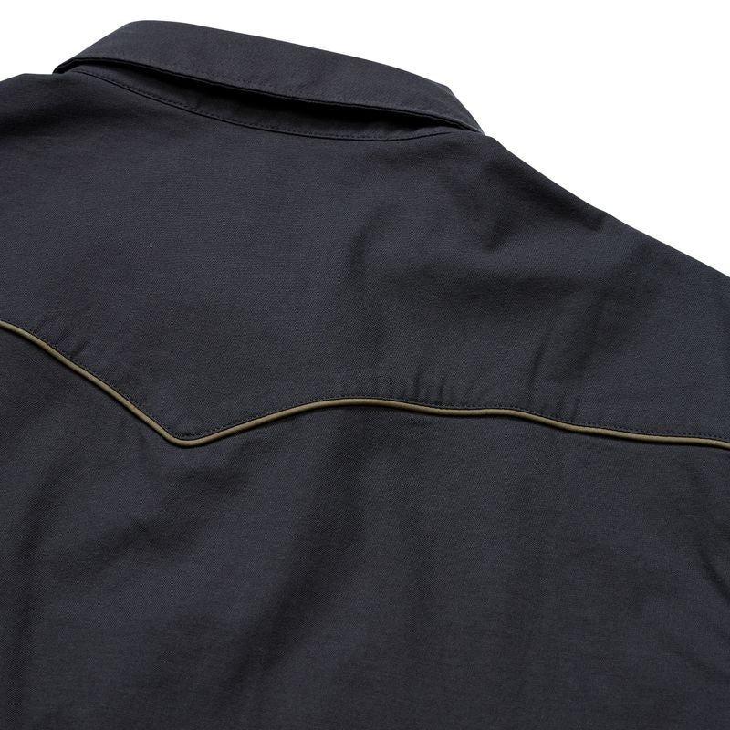 Close-up of a dark grey western-style shirt jacket showing the shoulder yoke, collar, and signature curved tan contrast stitching.