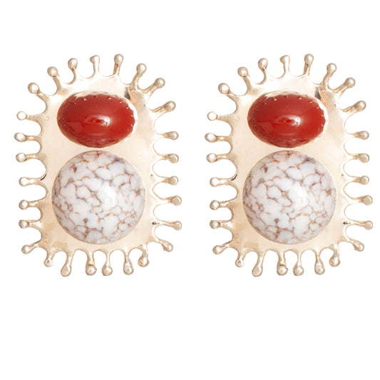 A pair of gold-toned earrings featuring a round red cabochon and a larger oval white stone with a brown marbled pattern, set in a crown-like gold frame on a white background.