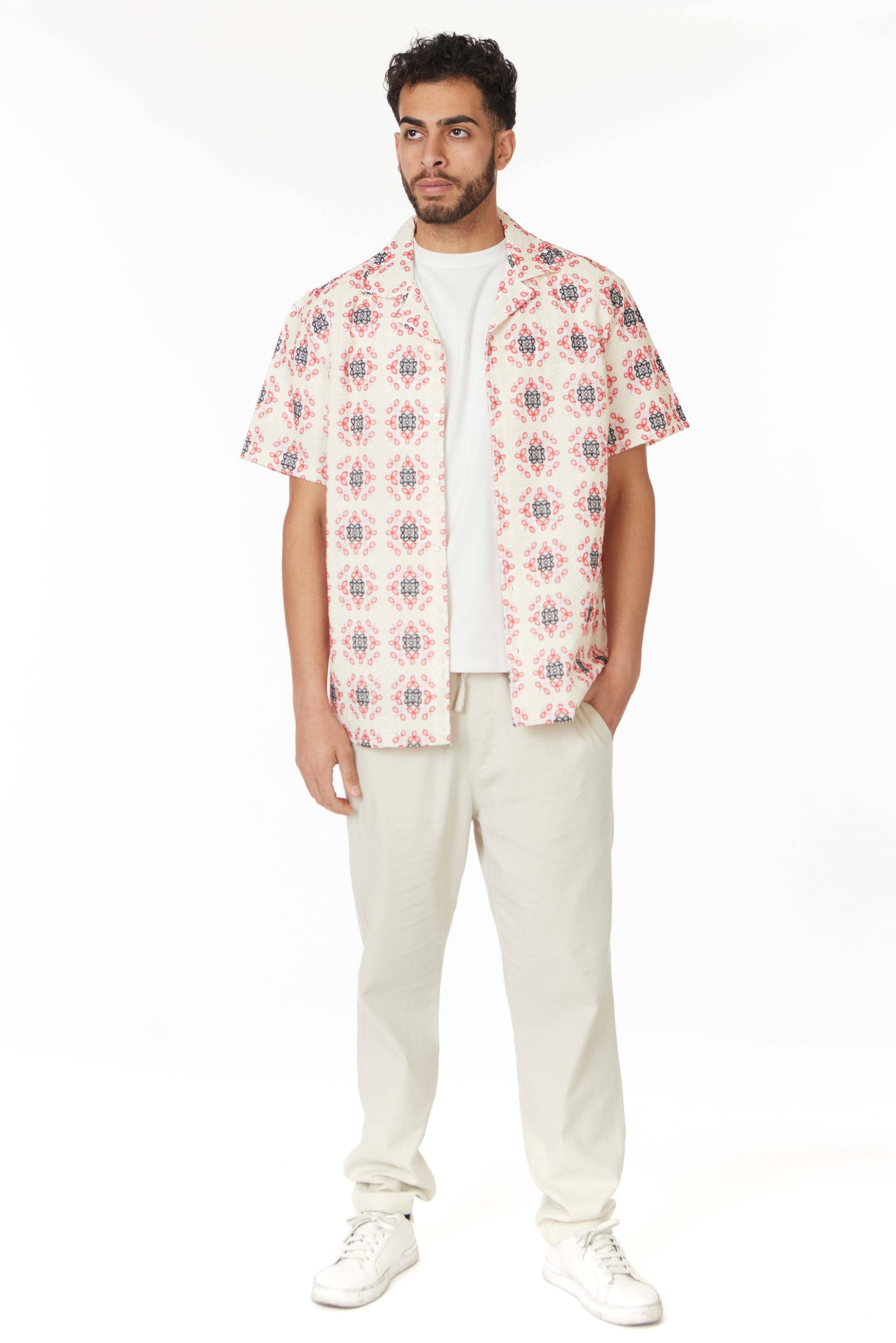 model in a short sleeve button down top with a red and blue floral print