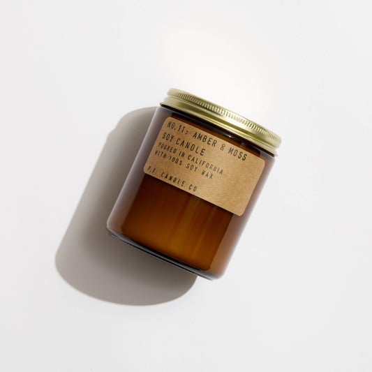 Brown candle with a gold lid on a white background