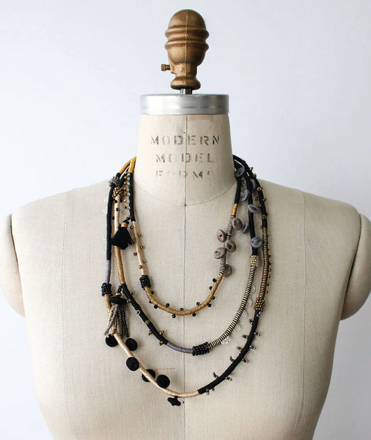 Necklace displayed on a mannequin bust with a plain background