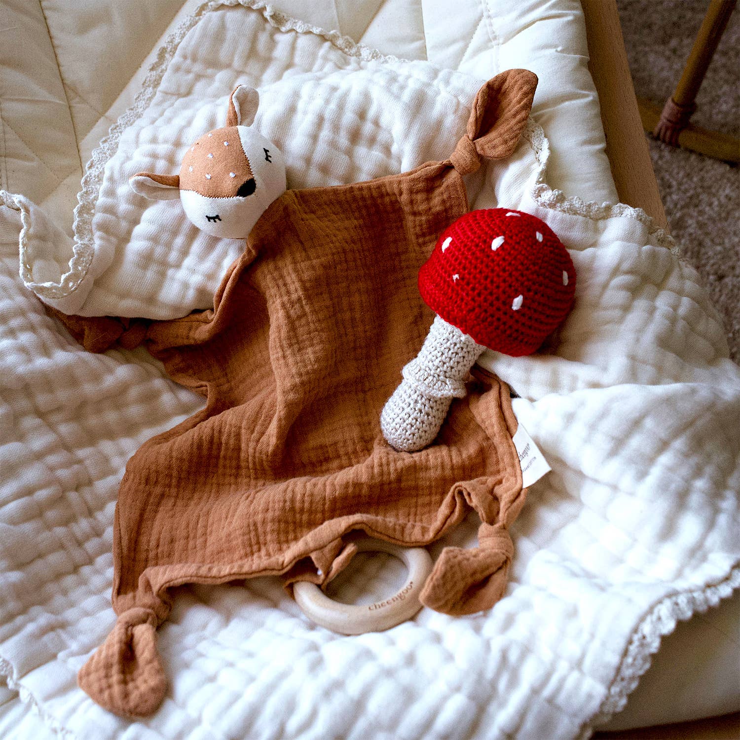 Baby comfort blanket with plush toys on a white surface