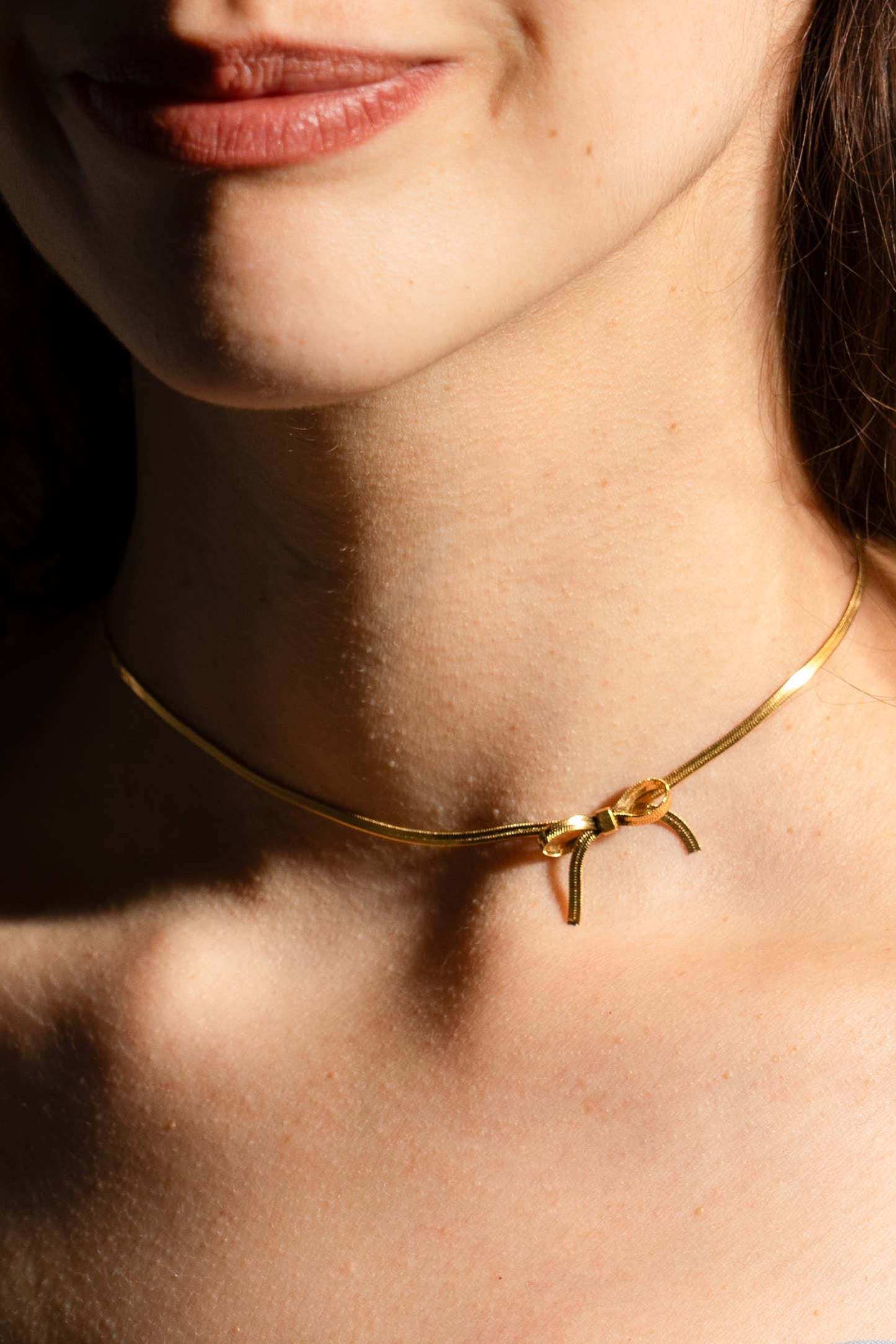  thin gold choker with a bow charm