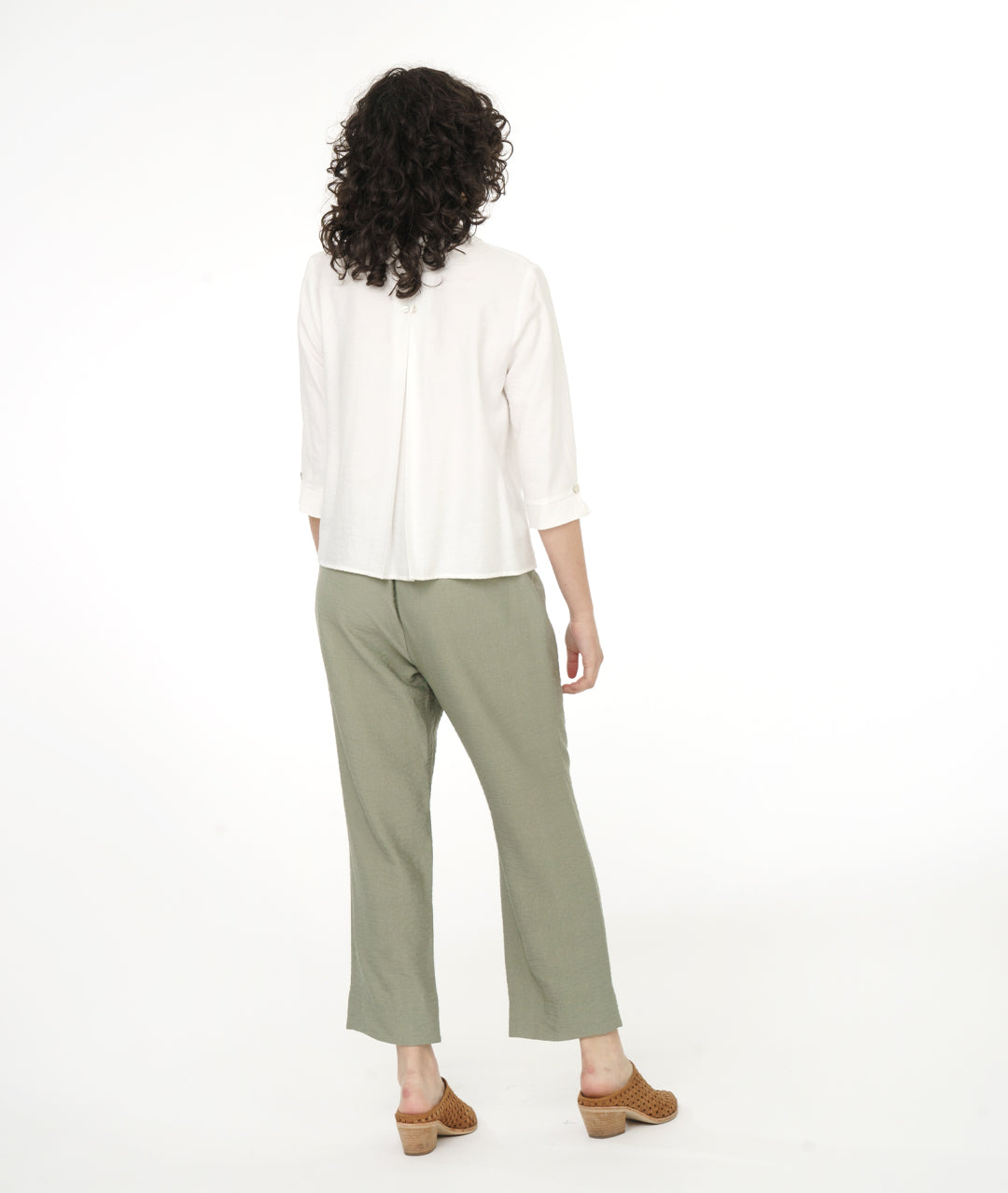 model in a white button down blouse with a soft moss green straight leg, elastic waist pant with center front side seams ending in a split at either ankle