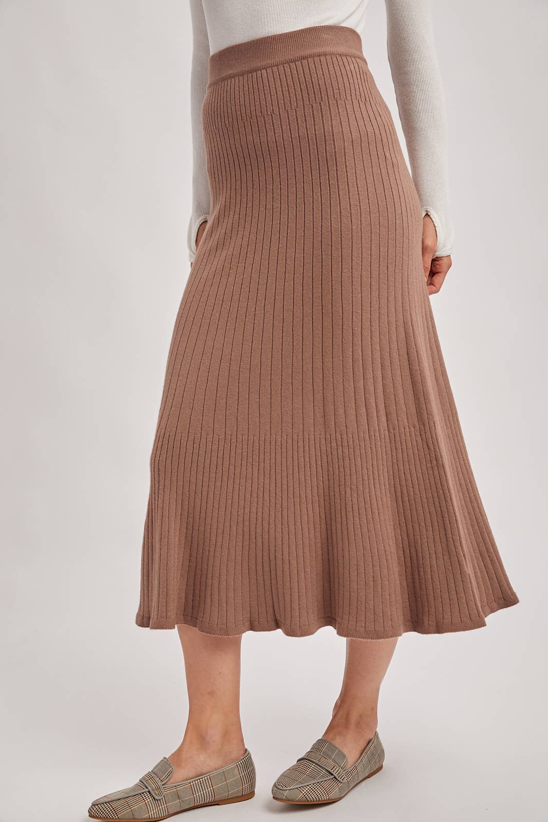 Brown ribbed skirt worn by a person on a white background
