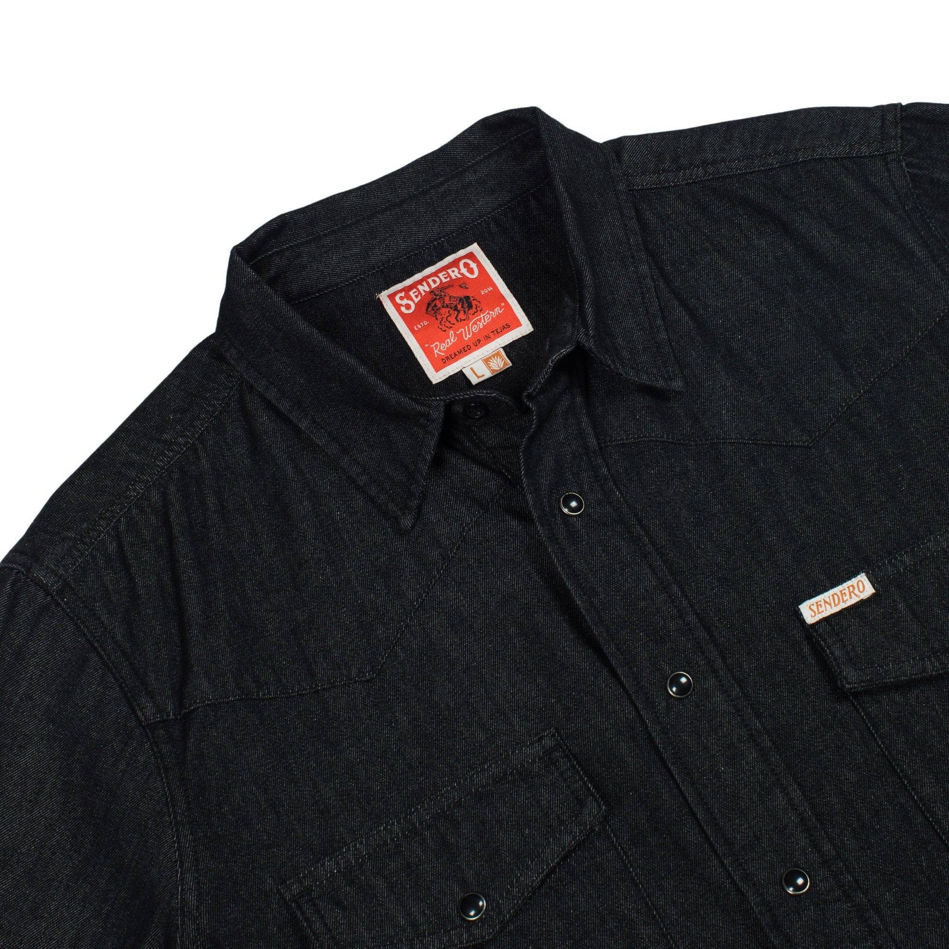 close up of black denim long sleeve shirt on a white background