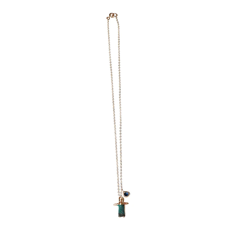 green worry doll charm on a gold chain necklace