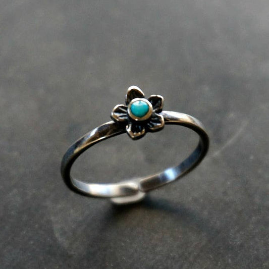 Silver ring with a turquoise stone on a gray background