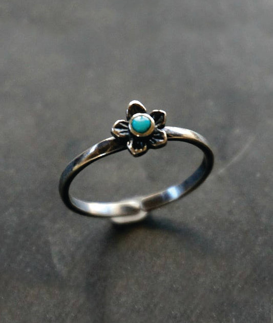 Silver ring with a turquoise stone on a gray background