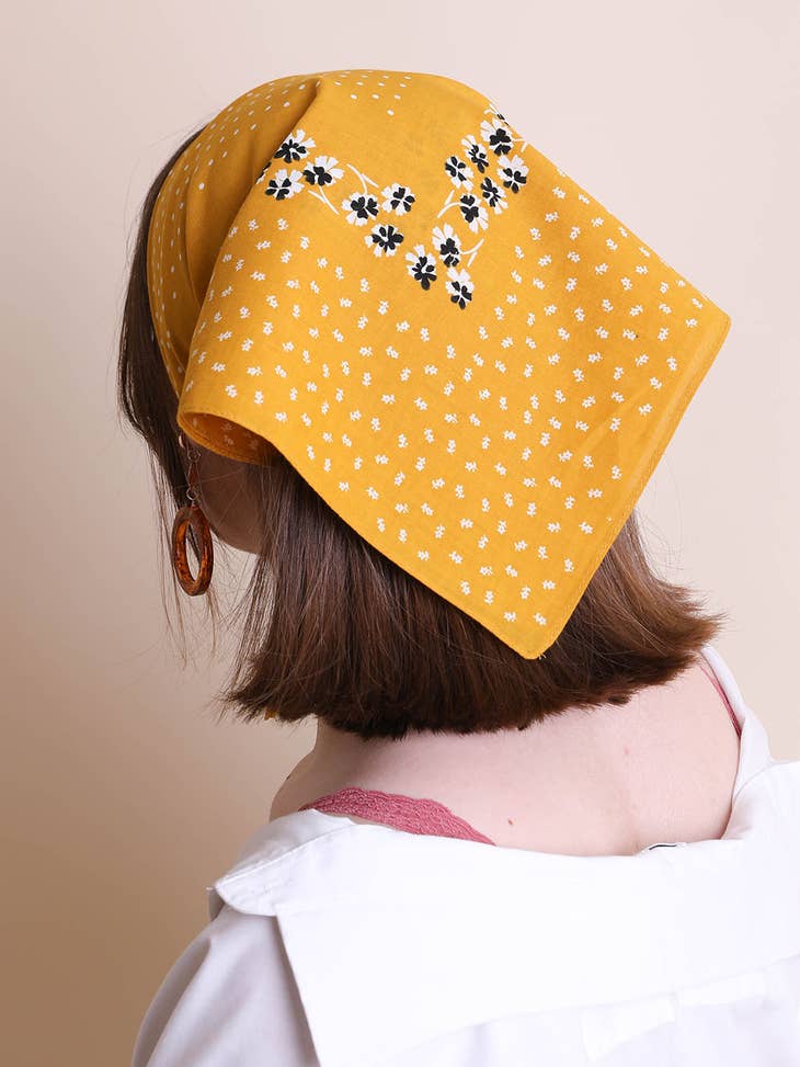 back view of a brunette model with a mustard yellow floral bandana in her hair