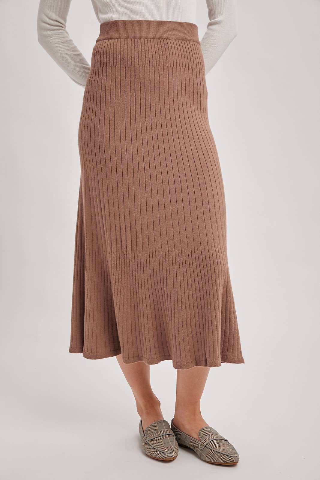 Person wearing a brown ribbed skirt on a white background
