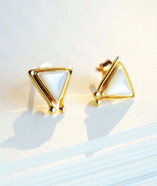 Gold triangle-shaped earrings on a light background