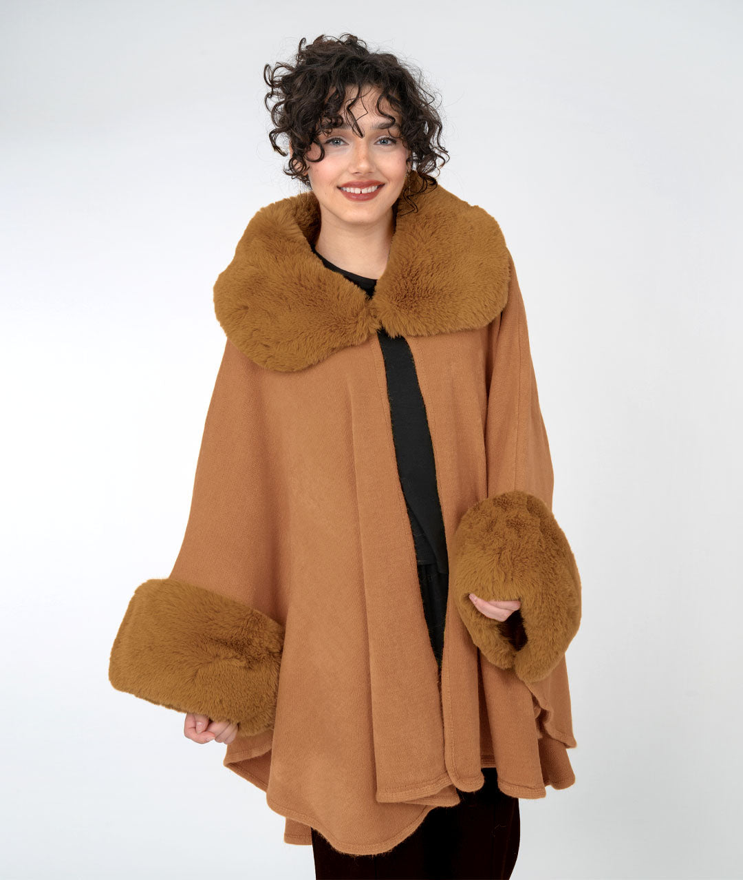Woman wearing a brown cape with fur collar and cuffs on a white background