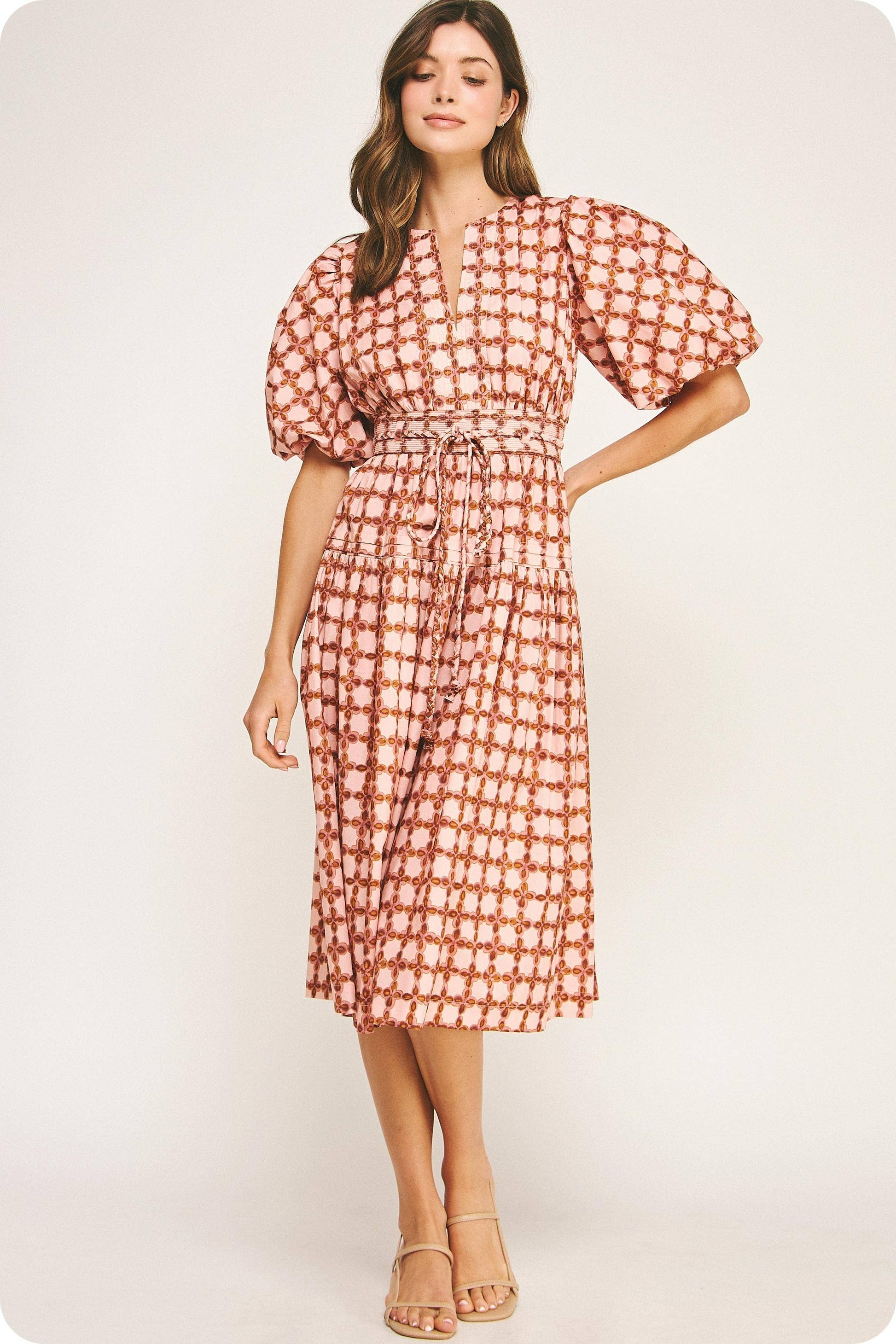 Woman wearing a red and white patterned dress on a white background