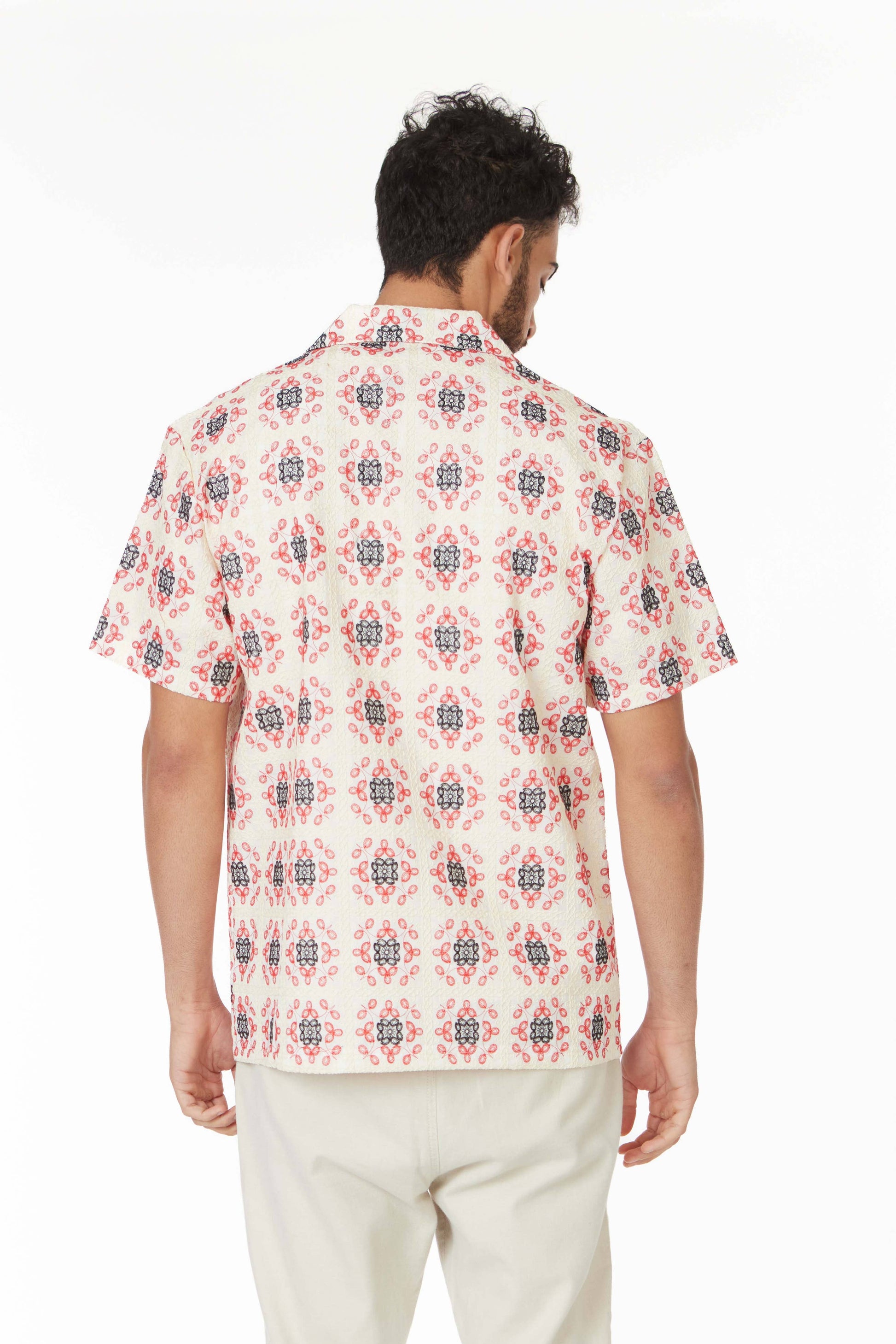 model in a short sleeve button down top with a red and blue floral print