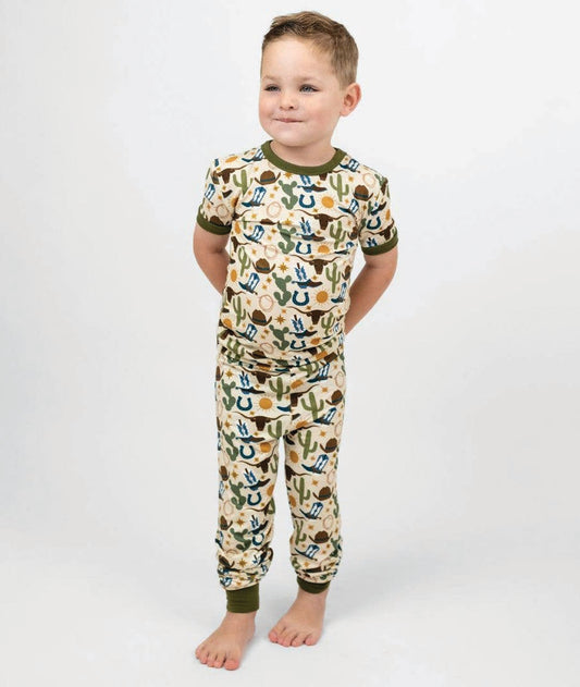 Child wearing a western patterned pajama on a plain background