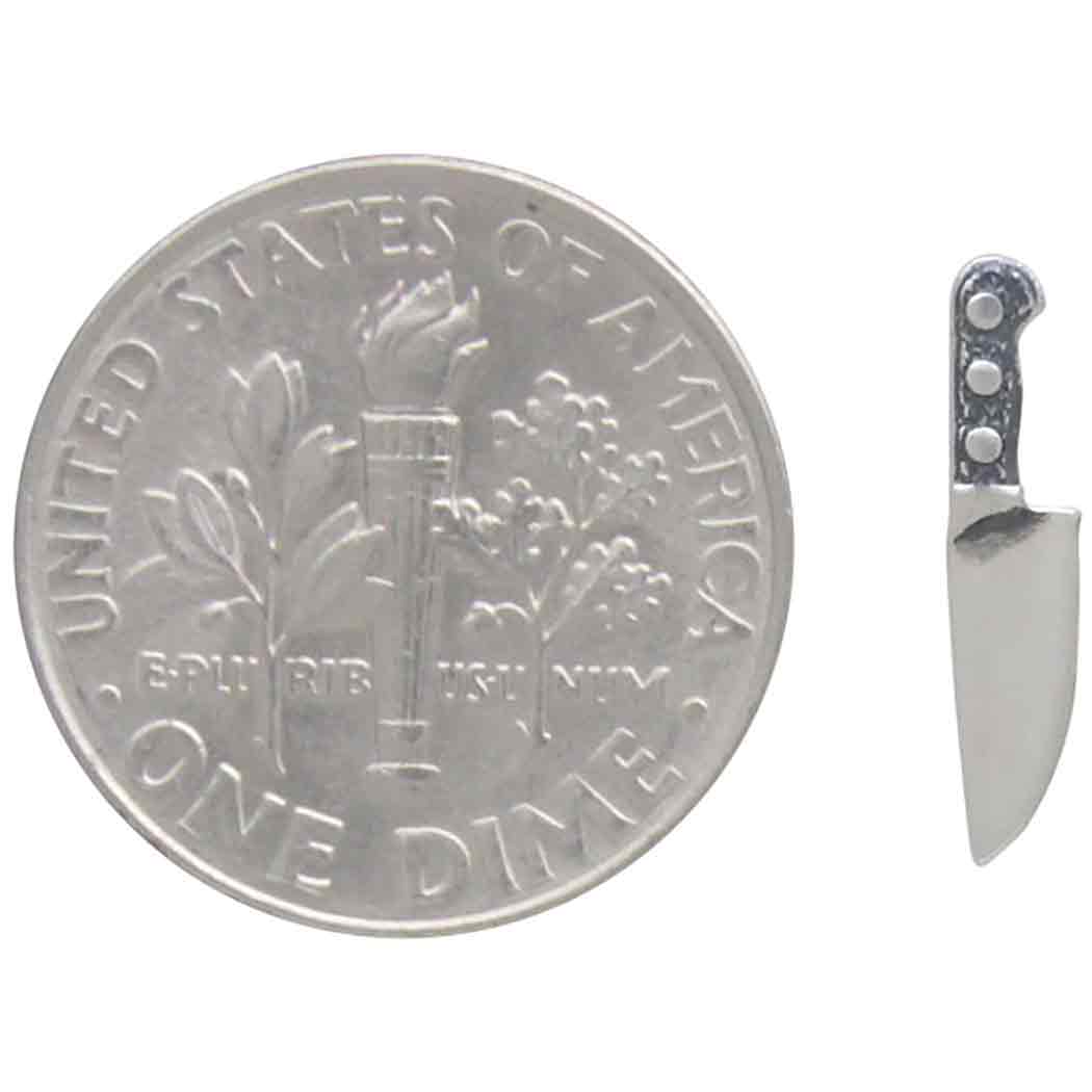 close up of knife earring ext to a US dime