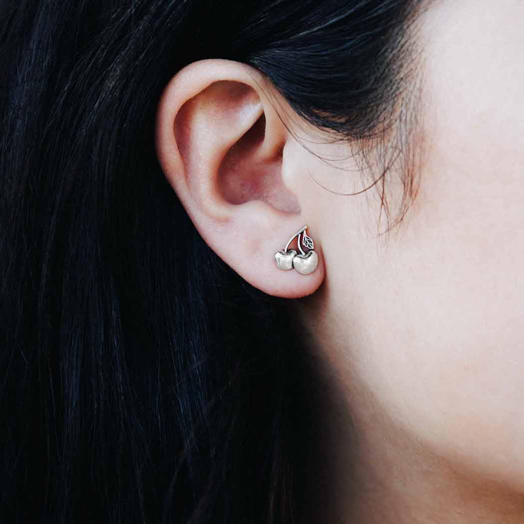 close up of cherry earrings on a model