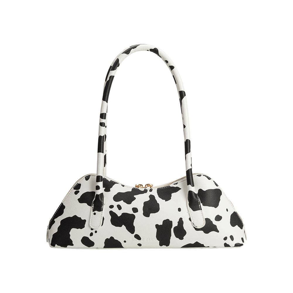 Black and white cow print handbag on a white background