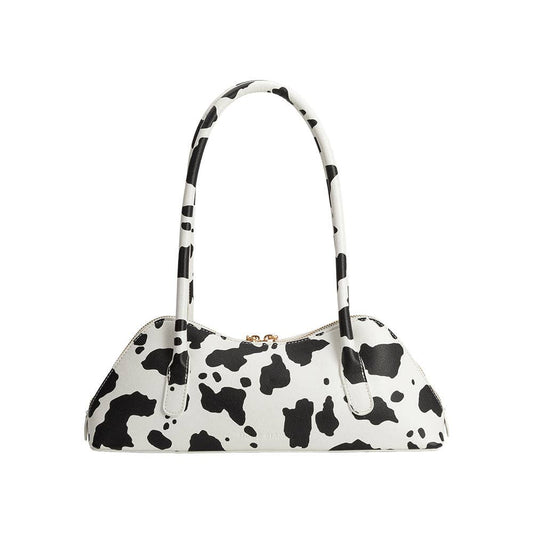 Black and white cow print handbag on a white background
