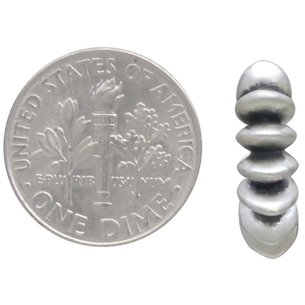 Silver spiral earring next to a U.S. dime on a white background
