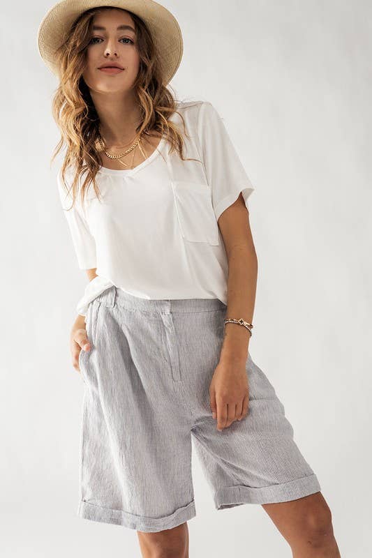 model wearing blue nautical stripe shorts, white shirt and hat