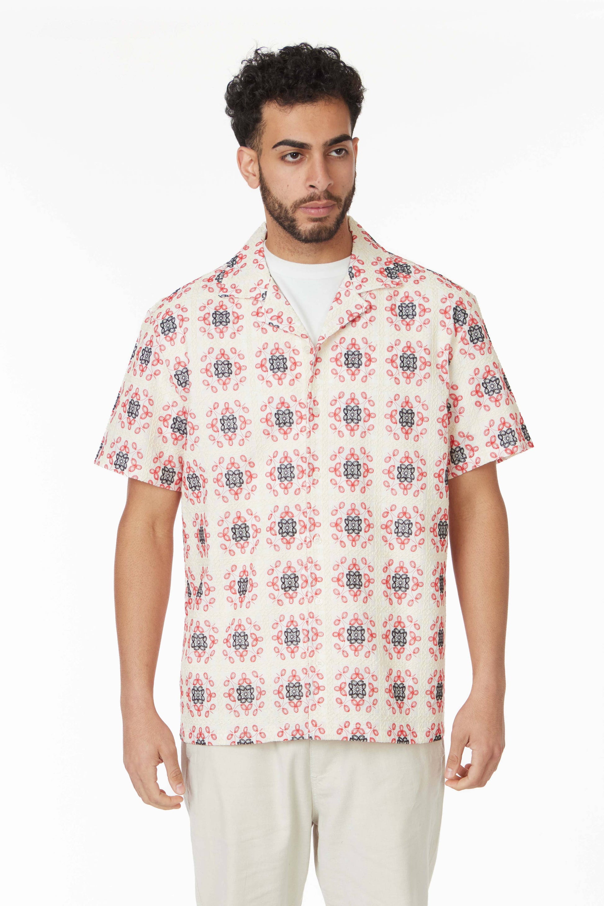 model in a short sleeve button down top with a red and blue floral print