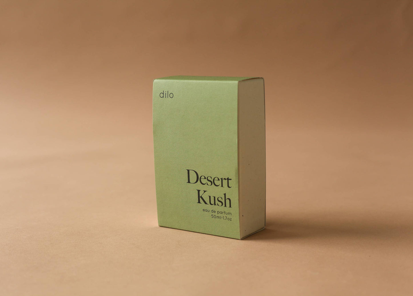 Green perfume box labeled 'Desert Kush' on a beige background