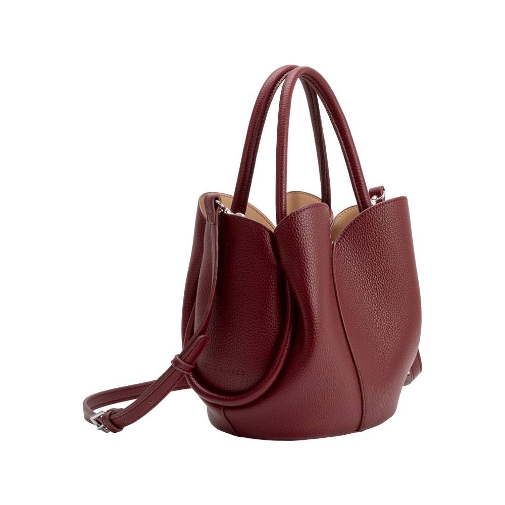 red leather handbag with a strap on a white background
