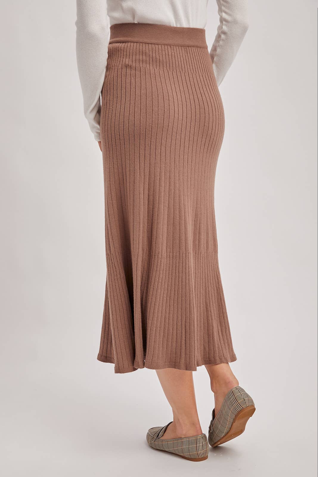 Brown ribbed skirt worn by a person on a white background