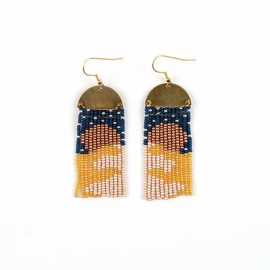 beaded fringe earring topped by a brass half moon withe blue and yellow sunset image on a white background